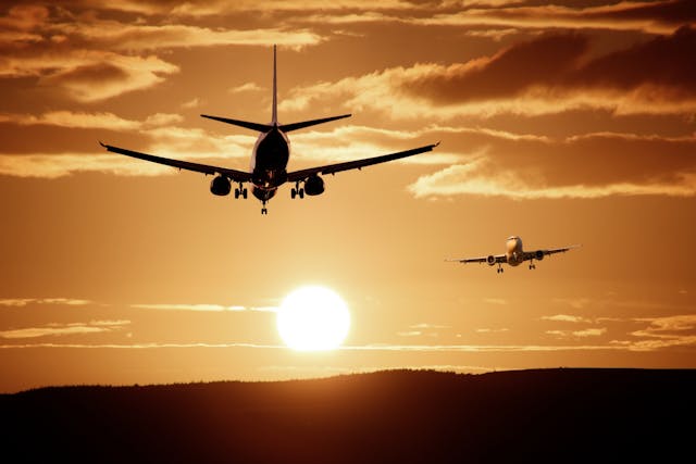 夕焼けの空を飛行中の飛行機