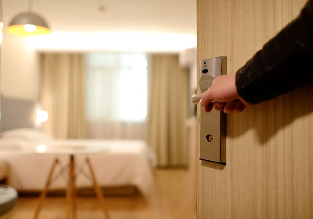 ホテルの部屋のドアを開けている宿泊客