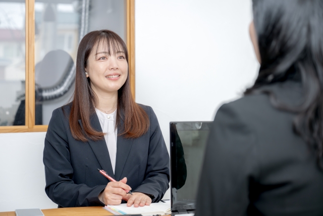 特定技能外国人からの相談を聞き取るビジネスウーマン