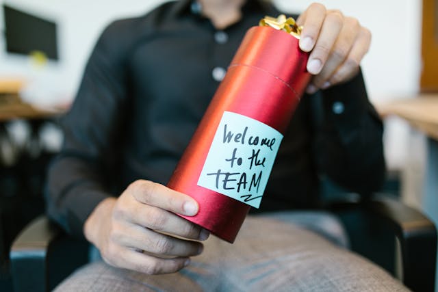 Welcom to the teamと書かれたギフトボックスを手にしている外国人社員