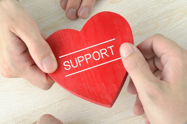 SUPPORTと書かれたハートを手渡すしている場面