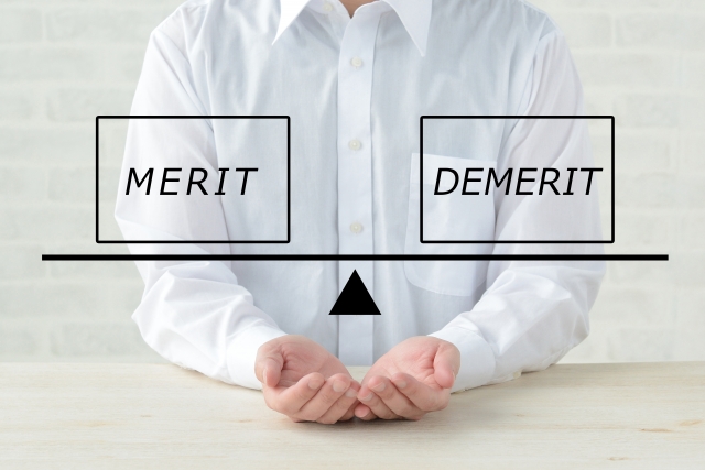 meritとdemeritの文字を天秤にかけている男性