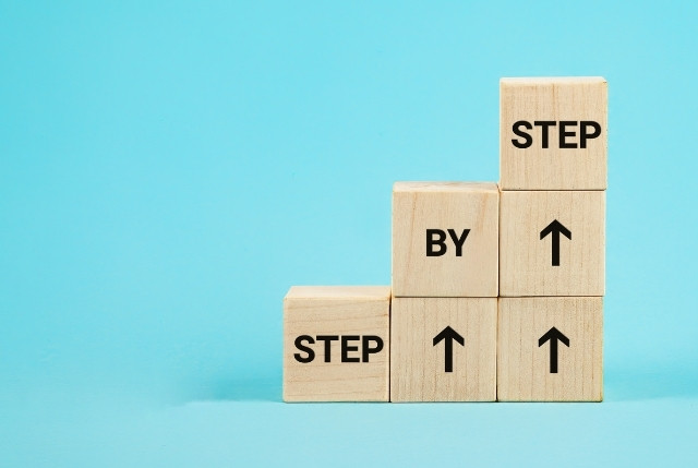 STEP BY STEPと書かれた木のブロック