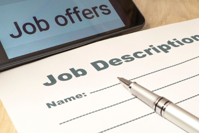 「Job offers」と表示されたタブレットと、応募者名を記入する欄がある「Job Description」用紙。採用活動や求人票作成のイメージ。
