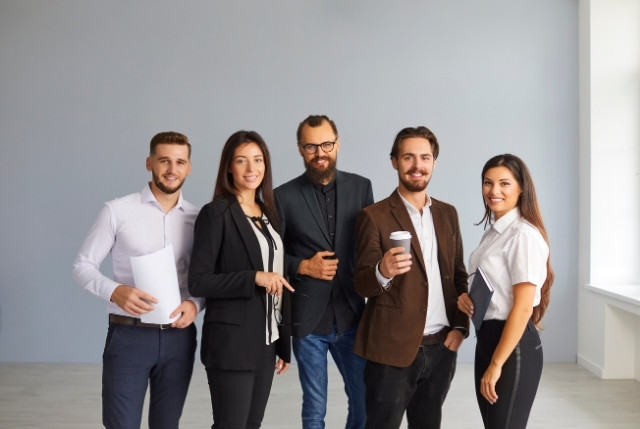外国人正社員の採用を検討する企業チームの集合写真。オフィスで若手ビジネスパーソンが並び、グローバル人材の求人・採用をイメージさせる場面