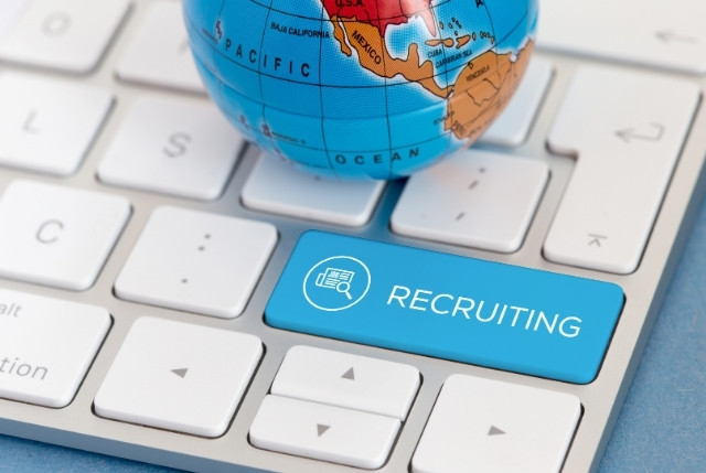 グローバル人材採用を象徴するキーボードの“RECRUITING”キーと地球儀
