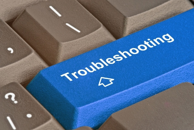 青色のキーボードキーにTroubleshootingと書かれたクローズアップ画像。外国人労働者の雇用や就労ビザ申請に関する課題解決やトラブルシューティングを解説