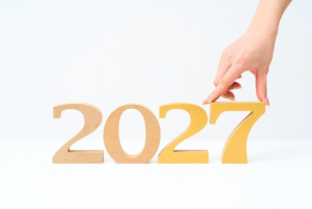 2027の数字オブジェを指で並べる様子。新制度への計画や目標設定、将来の展望を示すイメージ。