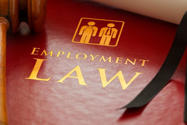 雇用法の書籍と木槌。外国人労働者の雇用や労働条件に関する法律・コンプライアンスを象徴するイメージ。