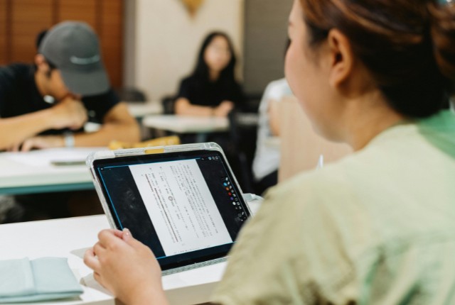 日本語学習 タブレットで日本語教材を学ぶ外国人社員。企業の日本語学習支援や研修風景を示すイメージ。